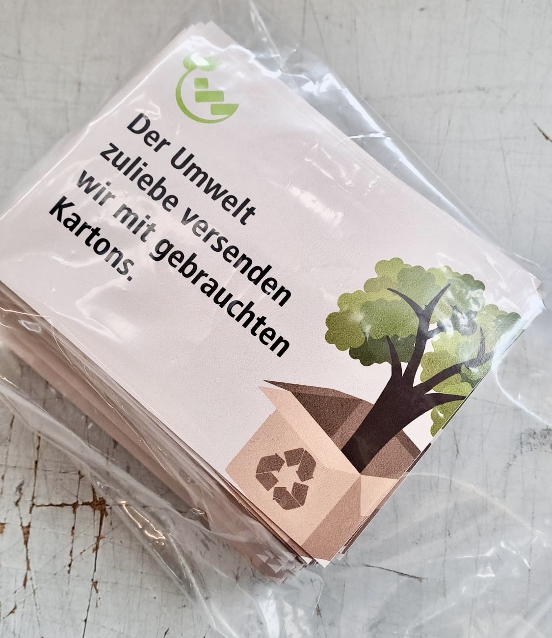 Aufkleber auf gebrauchten Kartonschachteln von Wagner Schriften für mehr Nachhaltigkeit